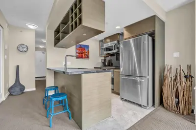 a kitchen with a stainless steel refrigerator and two blue stools at Corporate Stays Capitol Residences 1 Bedroom in Vancouver