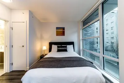 a bedroom with a bed and a large window at Corporate Stays Tate 1 Bedroom in Vancouver