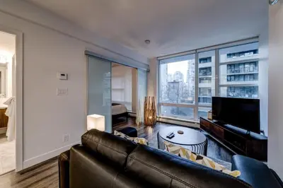 a living room with a couch and a large window at Corporate Stays Tate 1 Bedroom in Vancouver