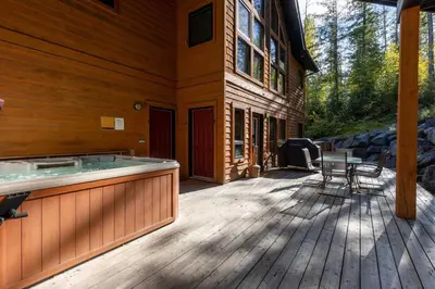 a deck with a hot tub on the side of a house at Black Diamond Chalet by Fernie Central Reservations in Fernie