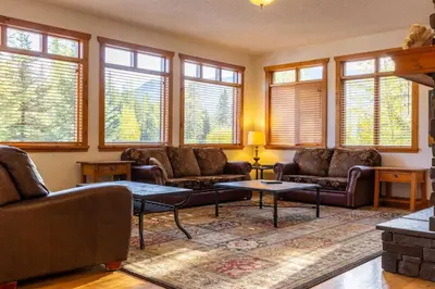 a living room with couches and tables and windows at Black Diamond Chalet by Fernie Central Reservations in Fernie