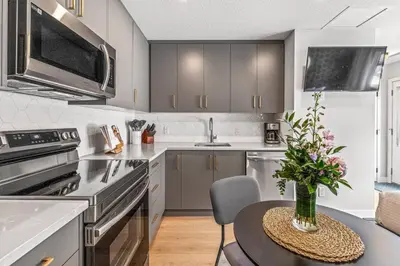 a kitchen with a table with a vase of flowers on it at Chick and Cozy Haven near Banff with Hot tub and Pool in Canmore