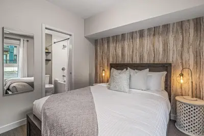 a bedroom with a large bed and a bathroom at Classic Modern 4BR Nearby DT Hot tub and Pool in Canmore