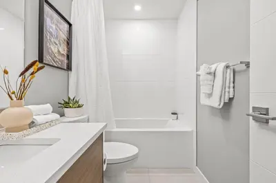 a white bathroom with a toilet and a shower at Mountain Modern 2BR Townhome with Stunning View in Canmore