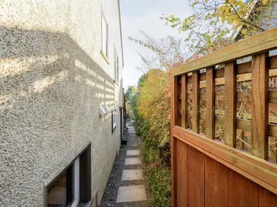 an alley between two buildings with a wooden fence at Gallery Garden - stylish, art-filled 1-bedroom suite by Victoria Prime! in Victoria