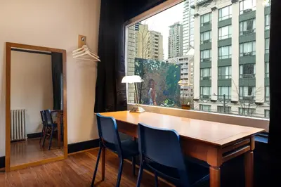 a dining room with a table and a large window at The Guesthouse Vancouver Downtown in Vancouver