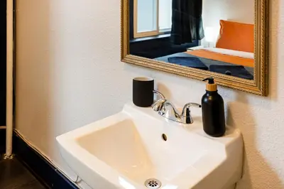 a bathroom with a sink and a mirror at The Guesthouse Vancouver Downtown in Vancouver