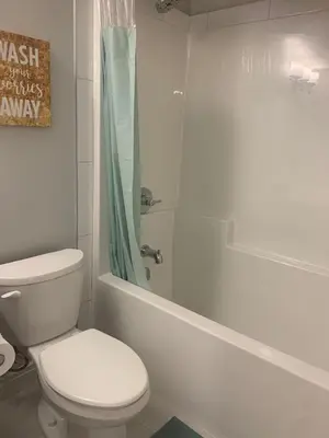 a white bathroom with a toilet and a shower at Modern and cozy stay-2 Bedroom Basement in Edmonton