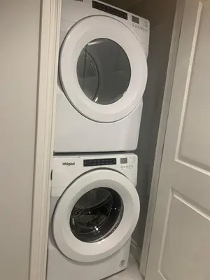 a washing machine and a washer in a bathroom at Modern and cozy stay-2 Bedroom Basement in Edmonton