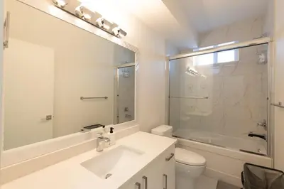 a white bathroom with a sink and a shower at Tranquil 2-Bedroom Basement Suite Relaxing Stay in Chilliwack
