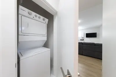 a white kitchen with a stove and a refrigerator at Tranquil 2-Bedroom Basement Suite Relaxing Stay in Chilliwack