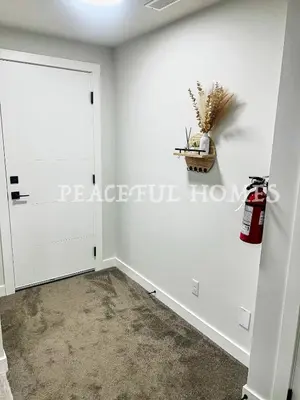 a room with a white wall and a door at Peaceful Homes - Elegant 2 Bedroom Suite in Calgary
