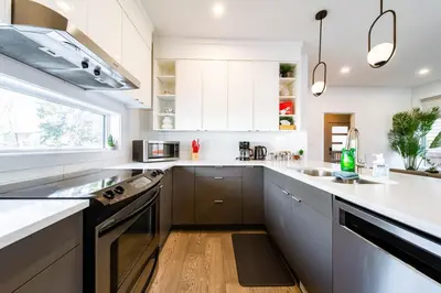 a kitchen with white cabinets and a large kitchen island at 9BDRM Chic Luxury Retreat-Hot Tub-BBQ-Sleeps 23! in Edmonton