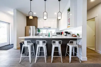 a kitchen with a large island with stools at 9BDRM Chic Luxury Retreat-Hot Tub-BBQ-Sleeps 23! in Edmonton