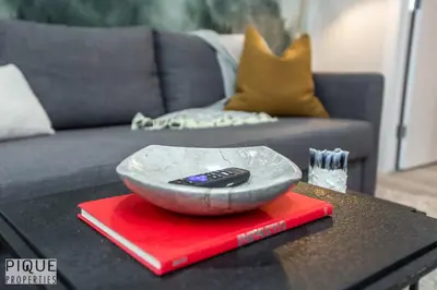 a remote control in a bowl on top of a table at Dual-Suite Getaway - Sleeps 12 - Whyte Ave - NFLX in Edmonton
