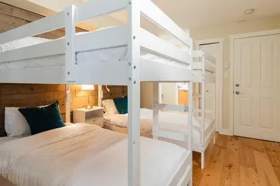 a bedroom with two bunk beds and a room with a bed at Private Hot Tub | Free Parking | Pool | Sauna in Whistler