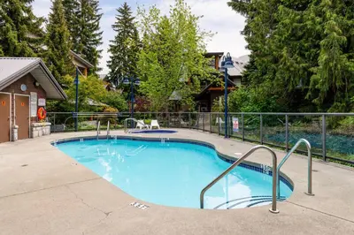 a large swimming pool with a fence around it at Private Hot Tub | Free Parking | Pool | Sauna in Whistler