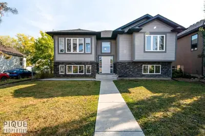 a large house with a driveway in a yard at Bright Modern Suites-King Beds-NFLX-WiFi-LongStays in Edmonton