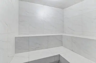 a white bathroom with white marble walls and shelves at Lakeview Retreat in West Kelowna in West Kelowna