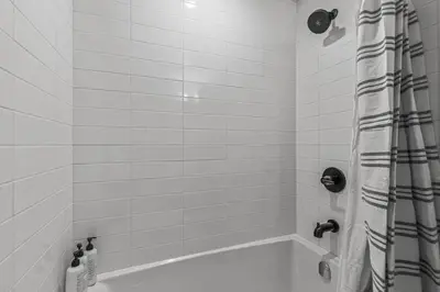 a bathroom with a tub with a shower curtain at New 3BR with Mountain Views Near DT Hot Tub and Pool in Canmore