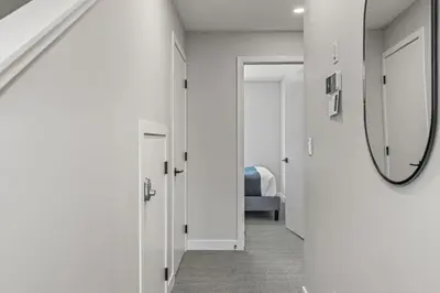 a hallway with a mirror and a room with a bed at 3BR with Stunning Views Self Check-In and Free Parking in Canmore