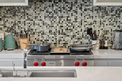 a kitchen with a stove with pots and pans on it at *One of a Kind* | Hot Tub| Air Hockey| Pool and… in Calgary