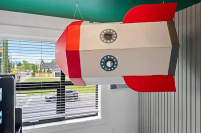 a toy ship hanging in a room with a window at *Spectacular* Sauna |Rocket-ship|Game-Room|Hammock in Calgary