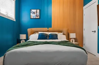 a bedroom with a large bed with blue walls at *Spectacular* Sauna |Rocket-ship|Game-Room|Hammock in Calgary