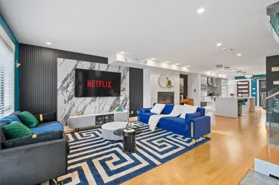 a living room with blue couches and a tv at *Spectacular* Sauna |Rocket-ship|Game-Room|Hammock in Calgary