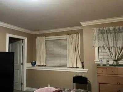 a bedroom with a window with curtains and a dresser at Barry and Elaine in Abbotsford