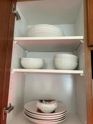 a cupboard filled with plates and bowls in a refrigerator at Luxurious & Spacious 4-Bedroom Vacation Home in Edmonton