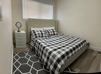 a bedroom with a bed with a black and white checkered blanket at Luxurious & Spacious 4-Bedroom Vacation Home in Edmonton