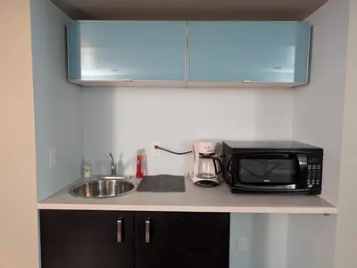 a kitchen counter with a microwave and a sink at 2-Room Suite in South Edmonton in Edmonton