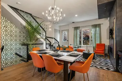 a dining room with a table and orange chairs at THE Getaway For BIG Groups-DT in Calgary