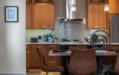 a kitchen with wooden cabinets and a table with chairs at THE Getaway For BIG Groups-DT in Calgary