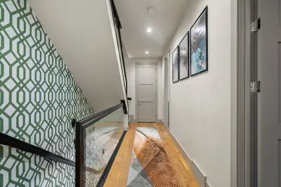 a staircase with a green and white patterned wall at THE Getaway For BIG Groups-DT in Calgary