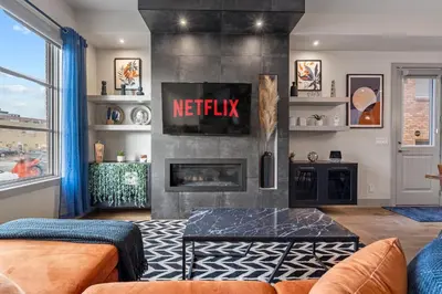 a living room with a fireplace and a tv at THE Getaway For BIG Groups-DT in Calgary
