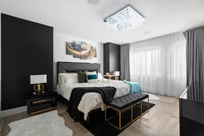 a black and white bedroom with a bed and a chair at *Everything*| Hot Tub| Sauna| Pool table|Game Room in Calgary