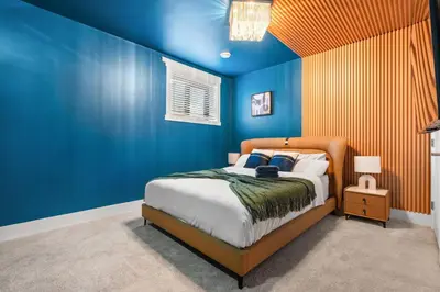 a blue bedroom with a bed and a blue wall at *Everything*| Hot Tub| Sauna| Pool table|Game Room in Calgary