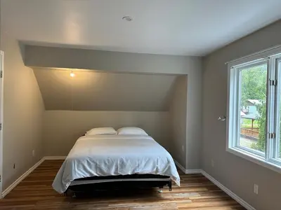 a bedroom with a bed and a window at Charming 4-Bedroom Home in Bella Coola in Hagensborg