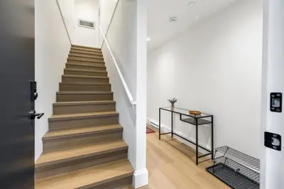 a staircase in a home with white walls and wooden floors at Brand-New Luxury Dunbar 4BR Home - Near UBC - Sleep 10 - Ideal for Family in Vancouver