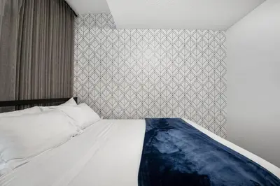 a bedroom with a white bed with a patterned wall at Modern Suburban Retreat in Ambleton Stylish Comfort Near Parks and Trails in Calgary
