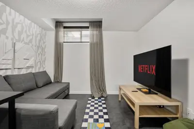 a living room with a couch and a tv at Modern Suburban Retreat in Ambleton Stylish Comfort Near Parks and Trails in Calgary