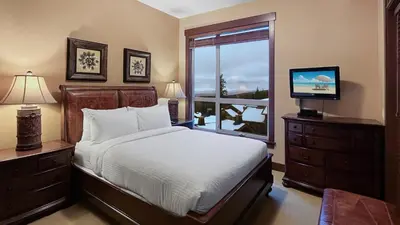 a bedroom with a bed and a tv and a window at Stonegate Resort Unit C403 in Big White
