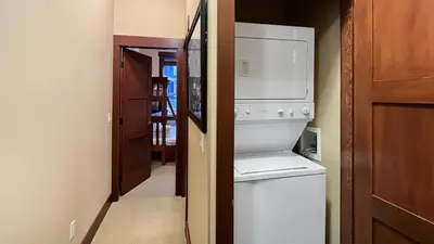a kitchen with a refrigerator and a washer and dryer at Stonegate Resort Unit C403 in Big White