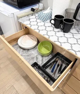 a drawer in a kitchen with plates and utensils at Excellent Place to Stay in Coquitlam