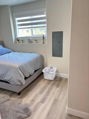 a bedroom with a bed and a window at Prince George Cozy Suite in Prince George