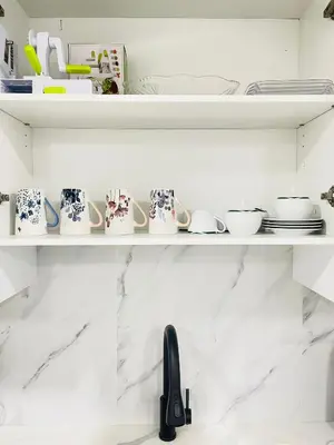 a shelf with cups and dishes on it at Ivey Homes in Edmonton