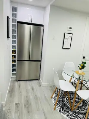 a kitchen with a stainless steel refrigerator and a table and chairs at Ivey Homes in Edmonton