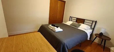 a room with a bed with a table and a bed sidx sidx sidx at Spacious Family Room with Shared Washroom in Vancouver